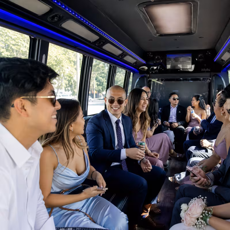 Wedding guests seated inside a San Jose party bus