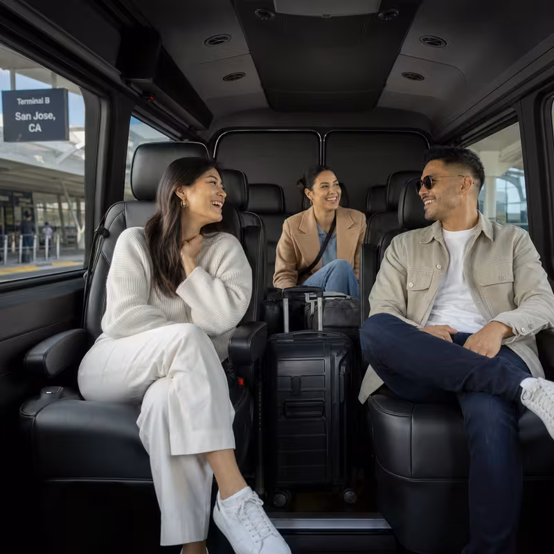 Passengers loading luggage while boarding an San Jose group shuttle